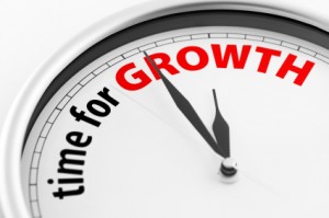 Close-up of a clock showing the words "Time For Growth". The color of "GROWTH" can easily be modified in photoshop by moving the Hue/Saturation slider.